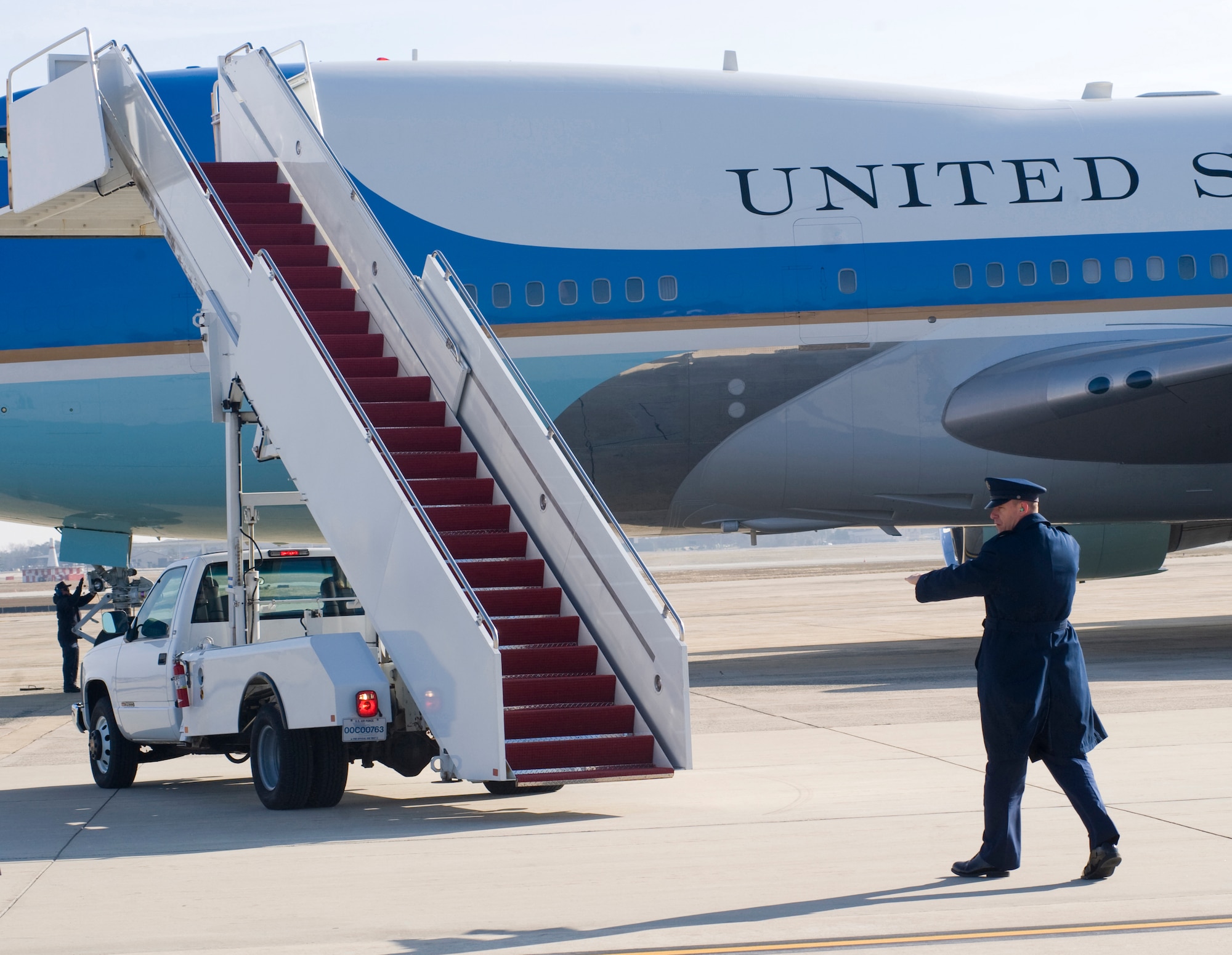 Tech. Sgt. Aubrey Lugo, 89th Aerial Port Squadron Special Air Mission Passenger (SAMPAX) service NCO in charge, spot assists a staircase truck backing away from Air Force One prior to takeoff here Jan. 25. SAMPAX provides a myriad of services in support of the 89 APS missions, such as coordinating with U.S. Secret Service to arrange security for foreign embassy representatives and distinguished visitor (D.V.) ground support. (Photo/Bobby Jones)