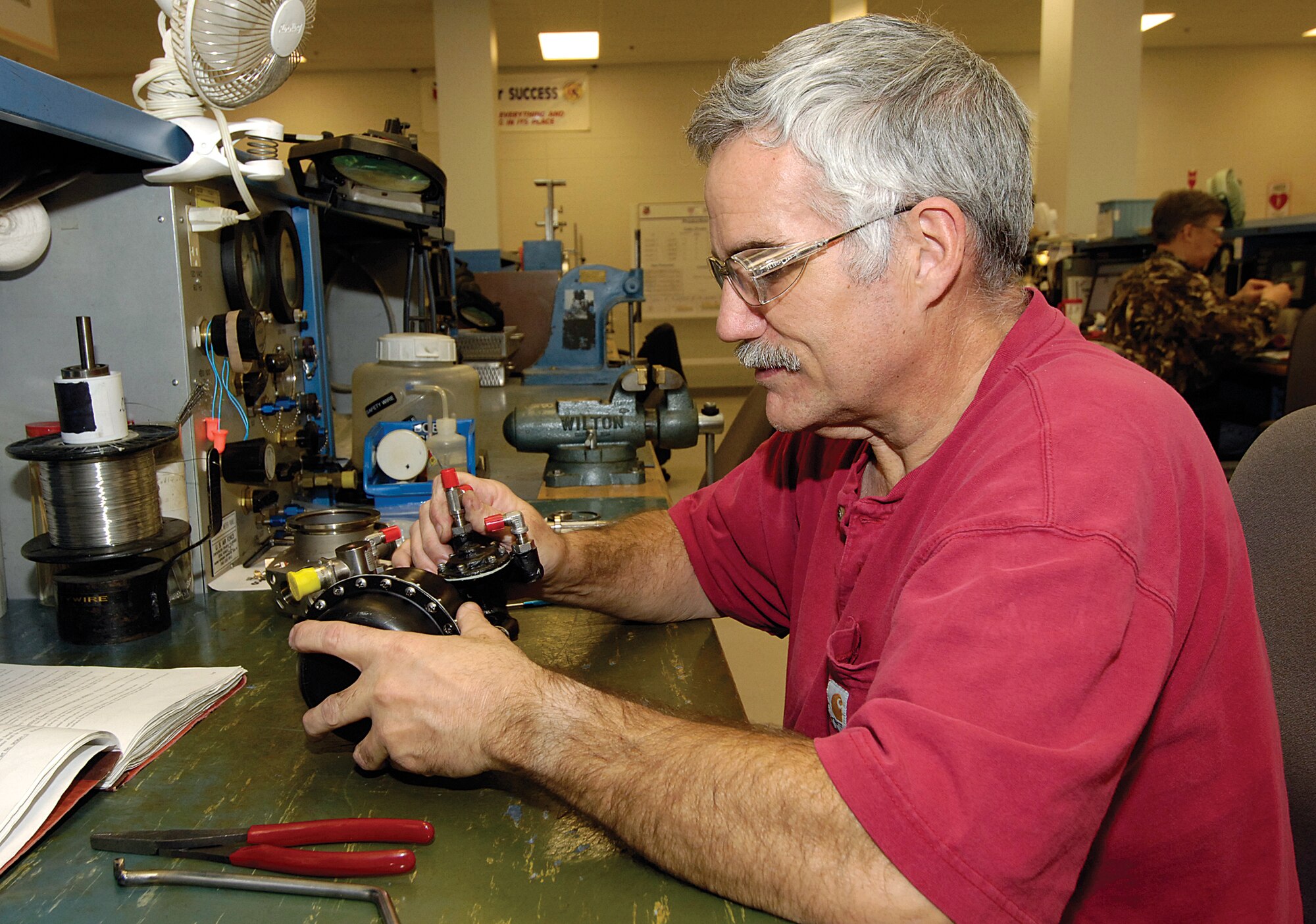 Robert Gilsbach, a pneudraulic system mechanic with the 76th Commodities Maintenance Group, works on an air shut off valve for a C-5 air turbine motor.  When wear on the small valve made it unrepairable, replacement came with a high-dollar price tag.  Mr. Gilsbach’s  low-cost  fix saved the Air Force thousands and earned the mechanic a $10,000 Air Force award. (Air Force photos by Margo Wright)