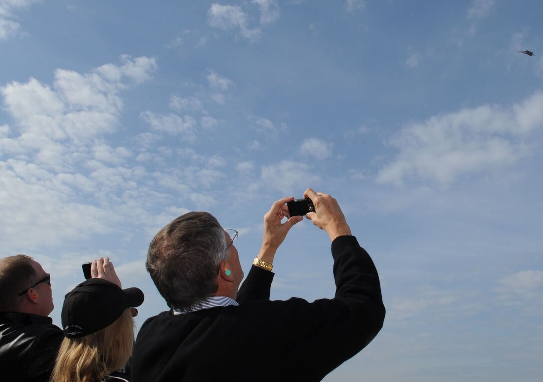 Air Force Civic Leaders take photos and videos of an F-22 Raptor as it performs aerial maneuvers during the Air Force Chief of Staff Civic Leader Tour at Langley Air Force Base, Va., Feb. 1, 2012. The Raptor is capable of maneuvering in ways unequalled by any other fighter jet in the world. (U.S. Air Force photo by Staff Sgt. Jeff Nevison/Released)