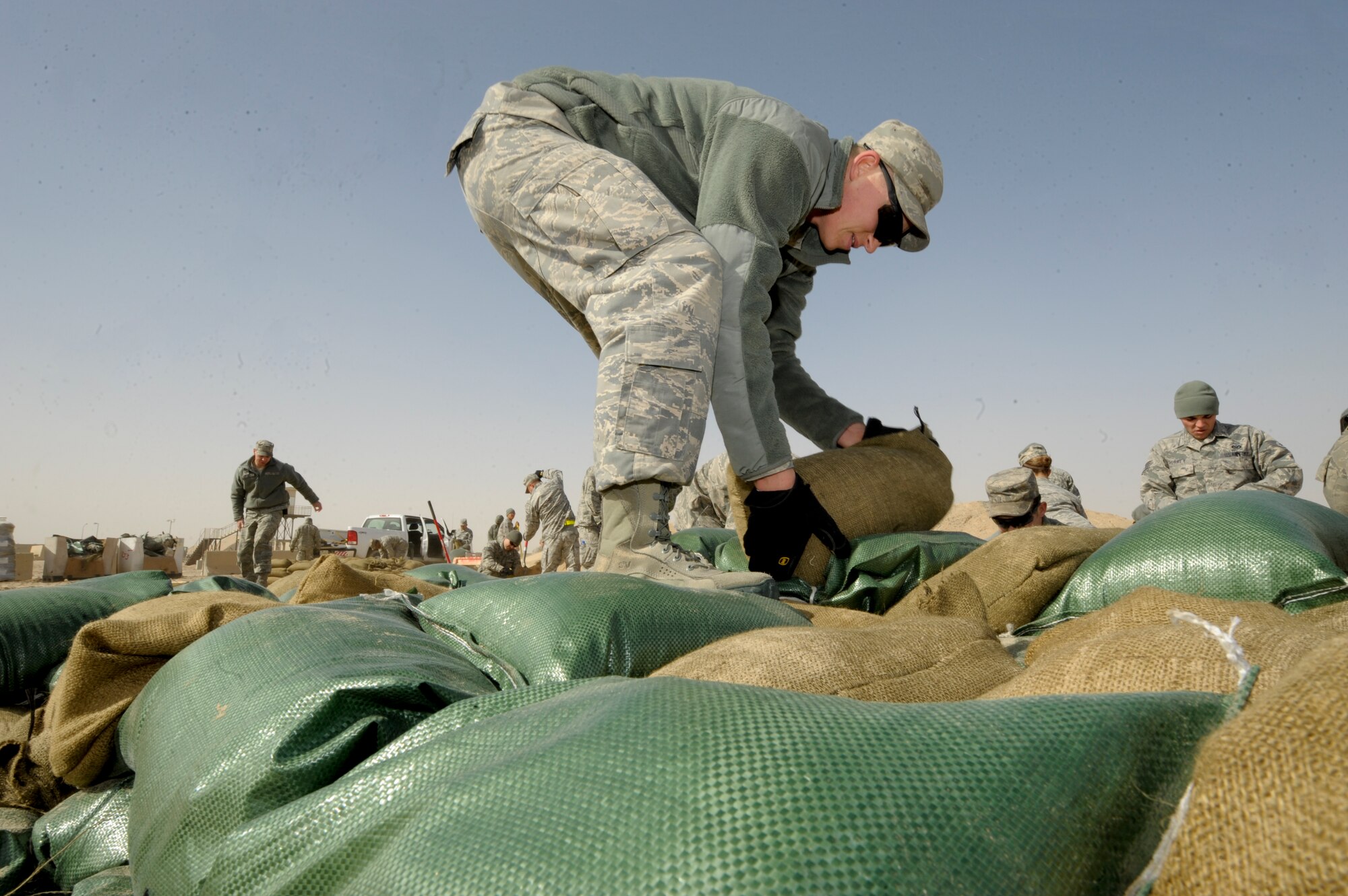 Senior Airman Marshall Hess, 332nd Expeditionary Civil Engineer Squadron, places sandbags on a pallet at an undisclosed location in Southwest Asia, Feb. 3, 2012. After the bags were filled with sand, they were stacked on pallets and moved to storage until needed. Hess is deployed from Davis-Montham Air Force Base, Ariz., and is a native of Paskenta, Calif. (U.S. Air Force photo by Staff Sgt. Joshua J. Garcia/Released)