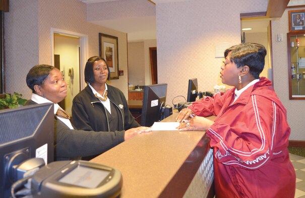 Liza Ward, Alfreda Masten and Fonda Bryant complete a transaction at the University Inn. The inn recently boosted its staff because of an increase in student occupancy.(Air Force photo/Desiree Garcia)