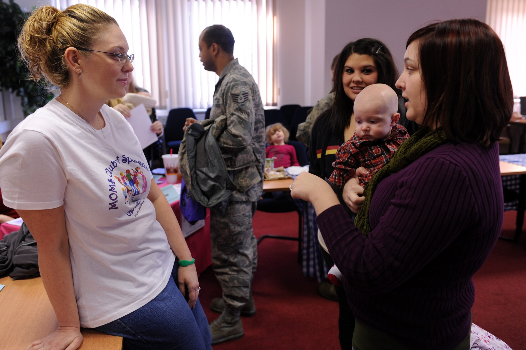 SPANGDAHLEM AIR BASE, Germany – Alexis Sargent, right, talks with Danel Walker about the MOMS Club during the “New Year New You” info and job fair at the Eifel Conference Center here Jan 31. MOMS Club is a support group for stay-at-home moms that provides activities and a forum for topics like child raising, homemaking, personal improvement and family. More than 20 organizations from on and off base attended the fair sponsored by the 52nd Force Support Squadron Airman and Family Readiness Center and the Volunteer Advisory Committee. The fair was held to help the base populace learn about community activities and get involved with organizations to work toward their New Year’s resolutions. (U.S. Air Force photo/Airman 1st Class Matthew B. Fredericks)
