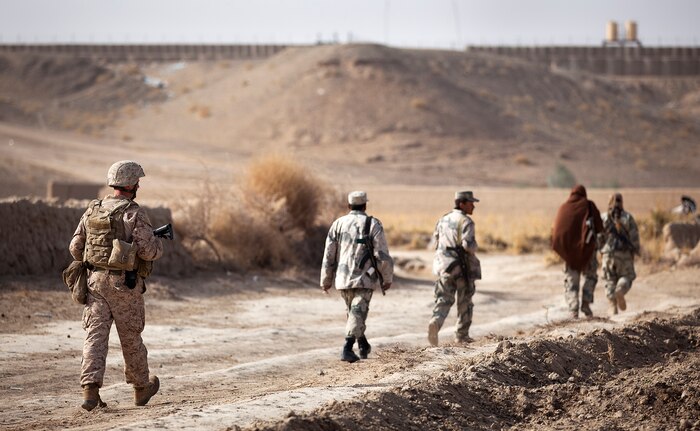 U.S. Marine Staff Sgt. Timothy Easterly, a member of the Border Advisor Team 2 in support of 1st Light Armored Reconnaissance Battalion, and members of the Afghan Border Police return to Patrol Base Pay Banadar during a partnered security patrol here, Jan. 30. In southern Garmsir district, an area with a history of tribal conflict, the growing ABP force has deepened its roots and established governance through the mentorship of the 3/3 Weapons Co. Marines. The ABP is younger and significantly smaller than the Afghan National Army and police forces, but its mission is vital as Afghan forces prepare to assume lead security responsibility in Garmsir. “If the ABP didn’t exist, there would be holes all along Afghanistan’s southern border,” said Capt. Jason Armas, 33, the commanding officer of Weapons Co., 3/3, and a native of Rye, N.Y.