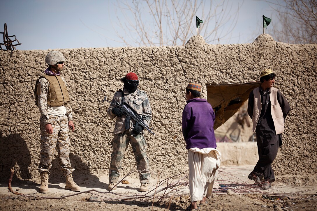 An interpreter and Afghan Border Police Pvt. Ghul Faruq, a medic with 2nd Tolai, 2nd Kandak, Helmand ABP, speak with a local boy while fellow ABP search a compound during a partnered security patrol with U.S. Marines from Combined Anti-Armor Team 2, Weapons Company, 3rd Battalion, 3rd Marine Regiment, here, Jan. 30. In southern Garmsir district, an area with a history of tribal conflict, the growing ABP force has deepened its roots and established governance through the mentorship of the 3/3 Weapons Co. Marines. The ABP is younger and significantly smaller than the Afghan National Army and police forces, but its mission is vital as Afghan forces prepare to assume lead security responsibility in Garmsir. “If the ABP didn’t exist, there would be holes all along Afghanistan’s southern border,” said Capt. Jason Armas, 33, the commanding officer of Weapons Co., 3/3, and a native of Rye, N.Y.