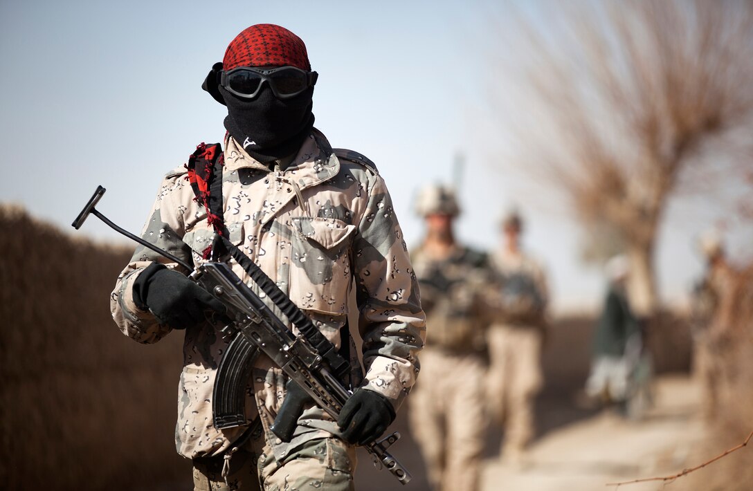 Afghan Border Police Pvt. Ghul Faruq, a medic with 2nd Tolai, 2nd Kandak, Helmand ABP, walks through a village during a partnered security patrol with U.S. Marines from Combined Anti-Armor Team 2, Weapons Company, 3rd Battalion, 3rd Marine Regiment, here, Jan. 30. In southern Garmsir district, an area with a history of tribal conflict, the growing ABP force has deepened its roots and established governance through the mentorship of the 3/3 Weapons Co. Marines. The ABP is younger and significantly smaller than the Afghan National Army and police forces, but its mission is vital as Afghan forces prepare to assume lead security responsibility in Garmsir. “If the ABP didn’t exist, there would be holes all along Afghanistan’s southern border,” said Capt. Jason Armas, 33, the commanding officer of Weapons Co., 3/3, and a native of Rye, N.Y.