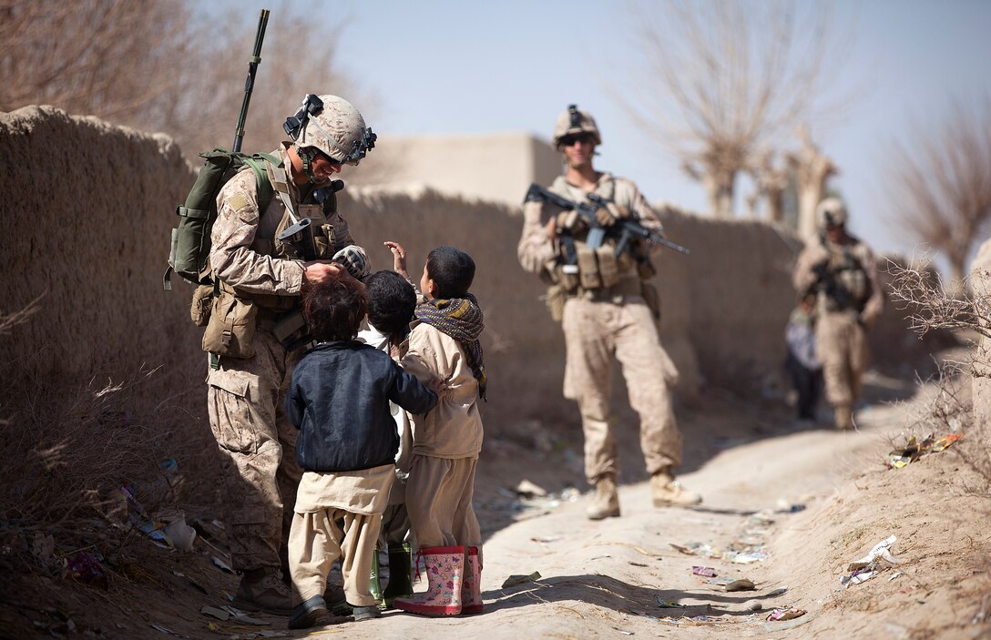 U.S. Marine Lance Cpl. Galen Murphy-Fahlgren, a 22-year-old anti-tank missileman with Combined Anti-Armor Team 2, Weapons Company, 3rd Battalion, 3rd Marine Regiment, and a native of Canton, Mich., hands candy to a group of Afghan children during a partnered security patrol with Afghan Border Police here, Jan. 30. In southern Garmsir district, an area with a history of tribal conflict, the growing ABP force has deepened its roots and established governance through the mentorship of the 3/3 Weapons Co. Marines. The ABP is younger and significantly smaller than the Afghan National Army and police forces, but its mission is vital as Afghan forces prepare to assume lead security responsibility in Garmsir. “If the ABP didn’t exist, there would be holes all along Afghanistan’s southern border,” said Capt. Jason Armas, 33, the commanding officer of Weapons Co., 3/3, and a native of Rye, N.Y.