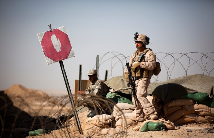 Afghan Border Police Sgt. Khan Jan, a patrolman with 2nd Tolai, 2nd Kandak, Helmand ABP, holds security with U.S. Marine Lance Cpl. Michael Medina, a 21-year-old machine gunner with Combined Anti-Armor Team 2, Weapons Company, 3rd Battalion, 3rd Marine Regiment, and a native of Woodbury, Minn., at the entry control point here, Jan. 30. In southern Garmsir district, an area with a history of tribal conflict, the growing ABP force has deepened its roots and established governance through the mentorship of the 3/3 Weapons Co. Marines. The ABP is younger and significantly smaller than the Afghan National Army and police forces, but its mission is vital as Afghan forces prepare to assume lead security responsibility in Garmsir. “If the ABP didn’t exist, there would be holes all along Afghanistan’s southern border,” said Capt. Jason Armas, 33, the commanding officer of Weapons Co., 3/3, and a native of Rye, N.Y.