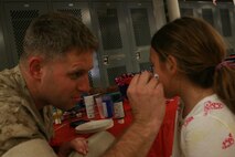 Sgt. Kris Jolley, Operations Non-Commissioned Officer, Headquarters and Support Battalion, Chemical Biological Incident Response Force, paints faces of children awaiting the return of their mothers and fathers from a month long deployment in support of Operation Tomodachi. The Marines of IRF A Deployed to Japan after a catastrophic earthquake and soon after tsunami shook the country and critically damaging the nuclear power plant Fukushima Dai-ichi. 