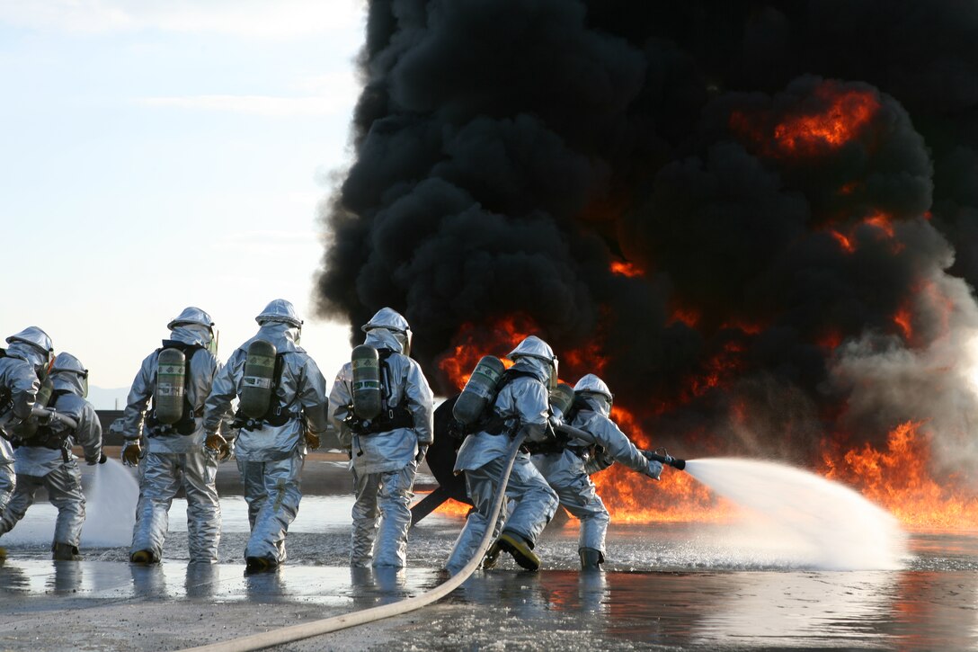 Marines with Aircraft Rescue and Firefighting charge toward the hot flames during a live-fire training exercise at the designated burn pit here Feb. 3. ARFF Marines are trained to stay low to the ground as they fight their red, orange and yellow nemesis, moving the hand-line in a back and forth motion to drown the flames in water. ARFF conducts bimonthly training to keep the Marines’ skills sharp and help them become confident in their technique, gear and each other.