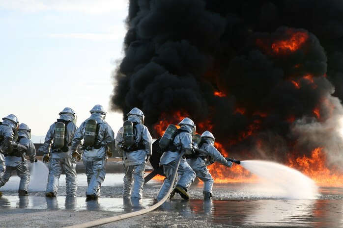 Marines with Aircraft Rescue and Firefighting charge toward the hot flames during a live-fire training exercise at the designated burn pit here Feb. 3. ARFF Marines are trained to stay low to the ground as they fight their red, orange and yellow nemesis, moving the hand-line in a back and forth motion to drown the flames in water. ARFF conducts bimonthly training to keep the Marines’ skills sharp and help them become confident in their technique, gear and each other.