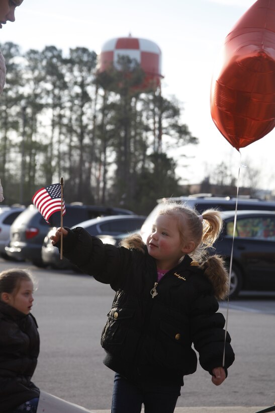 Felicity Lizotte, 2, waves a small American flag while she waits outside the Training and Education Building for her father, Cpl. Richard Lizotte, an aviation supply specialist with Marine Aviation Logistics Squadron 14, to return Feb. 4, 2012, after a 7-month deployment to Camp Bastion, Afghanistan. “I’m glad that we get to be a family again,” said his wife Nicole.