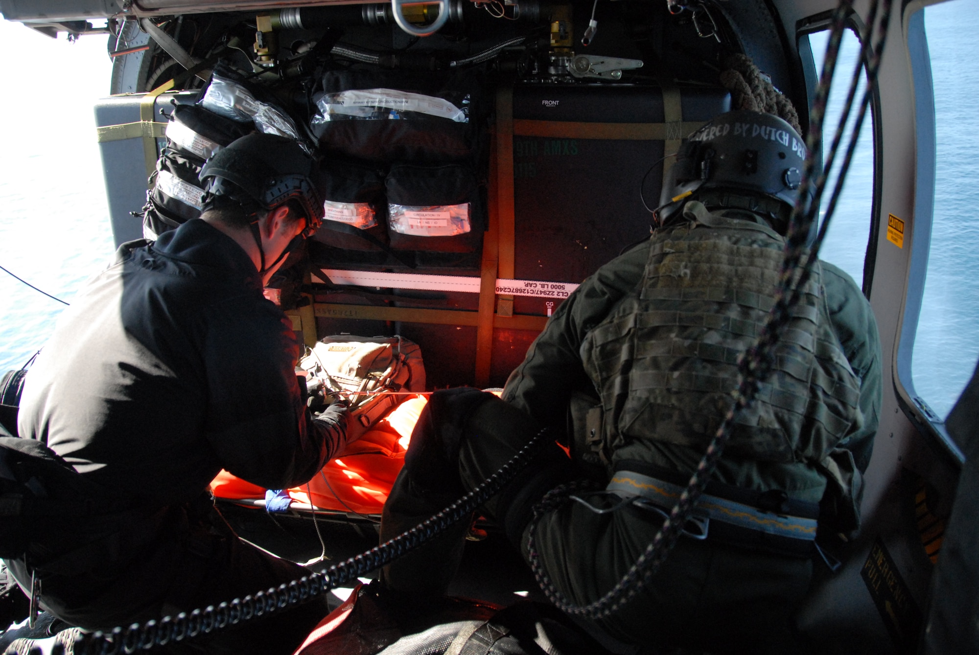Tech. Sgt. Sean Pellaton, an aerial gunner assigned to the 129th Rescue Squadron, and Staff Sgt. Adam Vanhaaster, a pararescueman assigned to the 131st Rescue Squadron, load a patient into the HH-60G Pave Hawk rescue helicopter Feb. 4, 2012. Responding to the call from the Eleventh District Coast Guard at Alameda, pararescuers, or PJs, two Pave Hawks and one MC-130P Combat Shadow aircraft departed Moffett Federal Airfield. The team provided medical assistance to a 54-year-old male who had suffered stroke-like symptoms on the MSC Beijing, acargo ship more than 200 miles off the coast of California. Guardsmen medically evacuated the patient to the San Jose Regional Medical Center. (Air National Guard photo by Senior Airman Jessica Green)