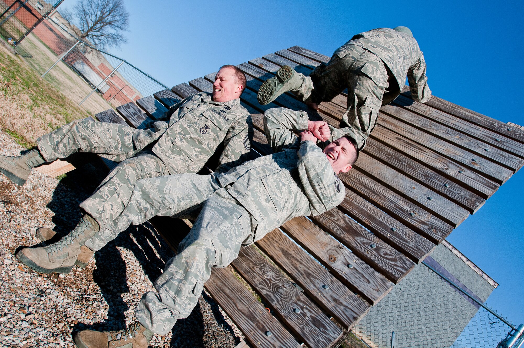 Staff Sgt. Ed Nooning and Master Sgt. Josh Devine, members of the Kentucky Air National Guard's 123rd Security Forces Squadron, help Tech. Sgt. Jesse Smith over an obstacle at Southern High School in Louisville, Ky., on Dec. 10, 2011. Airmen from the 123rd SFS were at the high school to use the Junior ROTC obstacle course for a team-building exercise as part of Wingman Day activities. (U.S. Air Force photo by Senior Airman Maxwell Rechel)