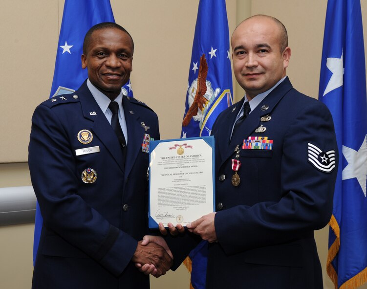 Air Force District of Washington Commander Maj. Gen. Darren W. McDew presents the Air Force Meritorious Service Medal to Tech. Sgt. Oscar J. Castro, unit training manager, Feb. 2, at the first commander’s call held in the Jacob E. Smart Center, Joint Base Andrews, Md. Castro Distinguished himself in the performance of outstanding service while serving as the 844th Communications Group training manager. (U.S. Air Force photo by Staff Sgt. Christopher Ruano)