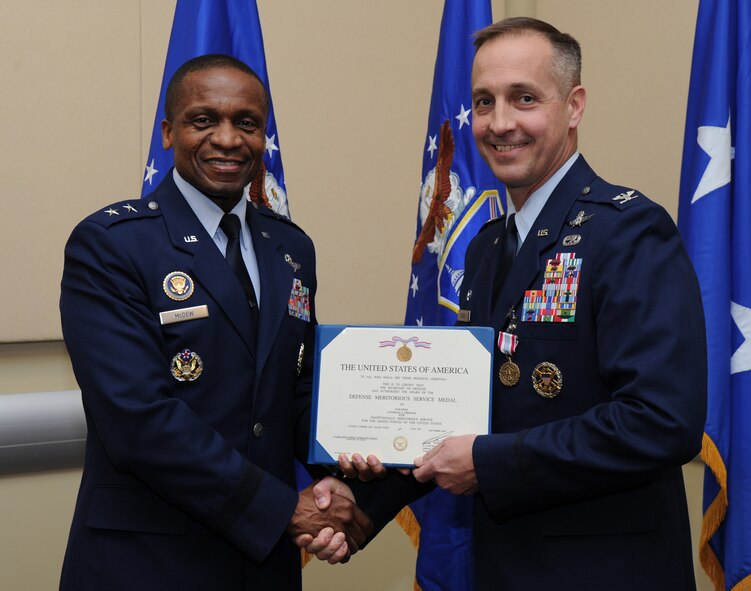 Air Force District of Washington Commander Maj. Gen. Darren W. McDew presents the Defense Meritorious Service Medal to Col. Anthony J. Thomas, 844th Communication Group commander; Feb. 2, at the first commander’s call held in the Jacob E. Smart Center, Joint Base Andrews, Md. McDew recognized eight AFDW Airmen for superior service and support. (U.S. Air Force photo by Staff Sgt. Christopher Ruano)