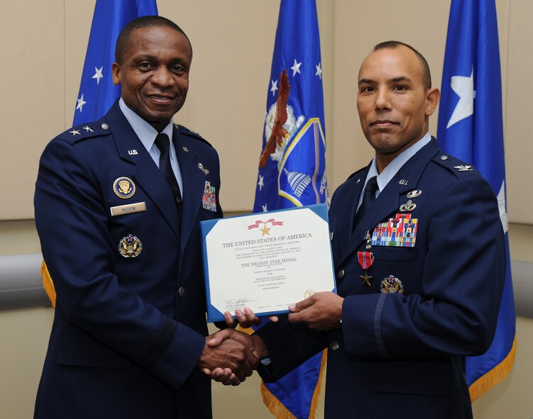 Air Force District of Washington Commander Maj. Gen. Darren W. McDew presents the Air Force Bronze Star Medal to Col. Michael Saunders, special assistant to the Air Force civil engineer for transformation, Feb. 2, at the first commander’s call held in the Jacob E. Smart Center, Joint Base Andrews, Md. McDew recognized eight AFDW Airmen for superior service and support. (U.S. Air Force photo by Staff Sgt. Christopher Ruano)