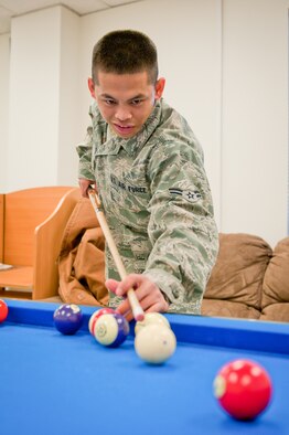 Airman 1st Class Reymart Relos, a food service specialist with the 123rd Force Support Squadron, plays pool during the reopening of the Kentucky Air National Guard's Morale, Welfare and Recreation facility in Louisville, Ky., on Jan. 7, 2012. The facility, now known as The Winner's Circle, also features a foosball table, a kitchen and a volleyball court. It is operated by the 123rd Force Support Squadron. (U.S. Air Force photo by Senior Airman Maxwell Rechel)