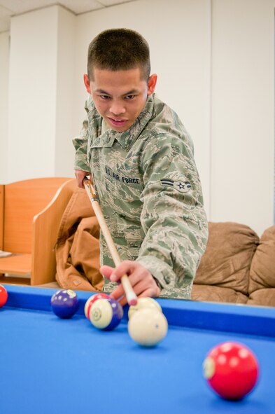 Airman 1st Class Reymart Relos, a food service specialist with the 123rd Force Support Squadron, plays pool during the reopening of the Kentucky Air National Guard's Morale, Welfare and Recreation facility in Louisville, Ky., on Jan. 7, 2012. The facility, now known as The Winner's Circle, also features a foosball table, a kitchen and a volleyball court. It is operated by the 123rd Force Support Squadron. (U.S. Air Force photo by Senior Airman Maxwell Rechel)