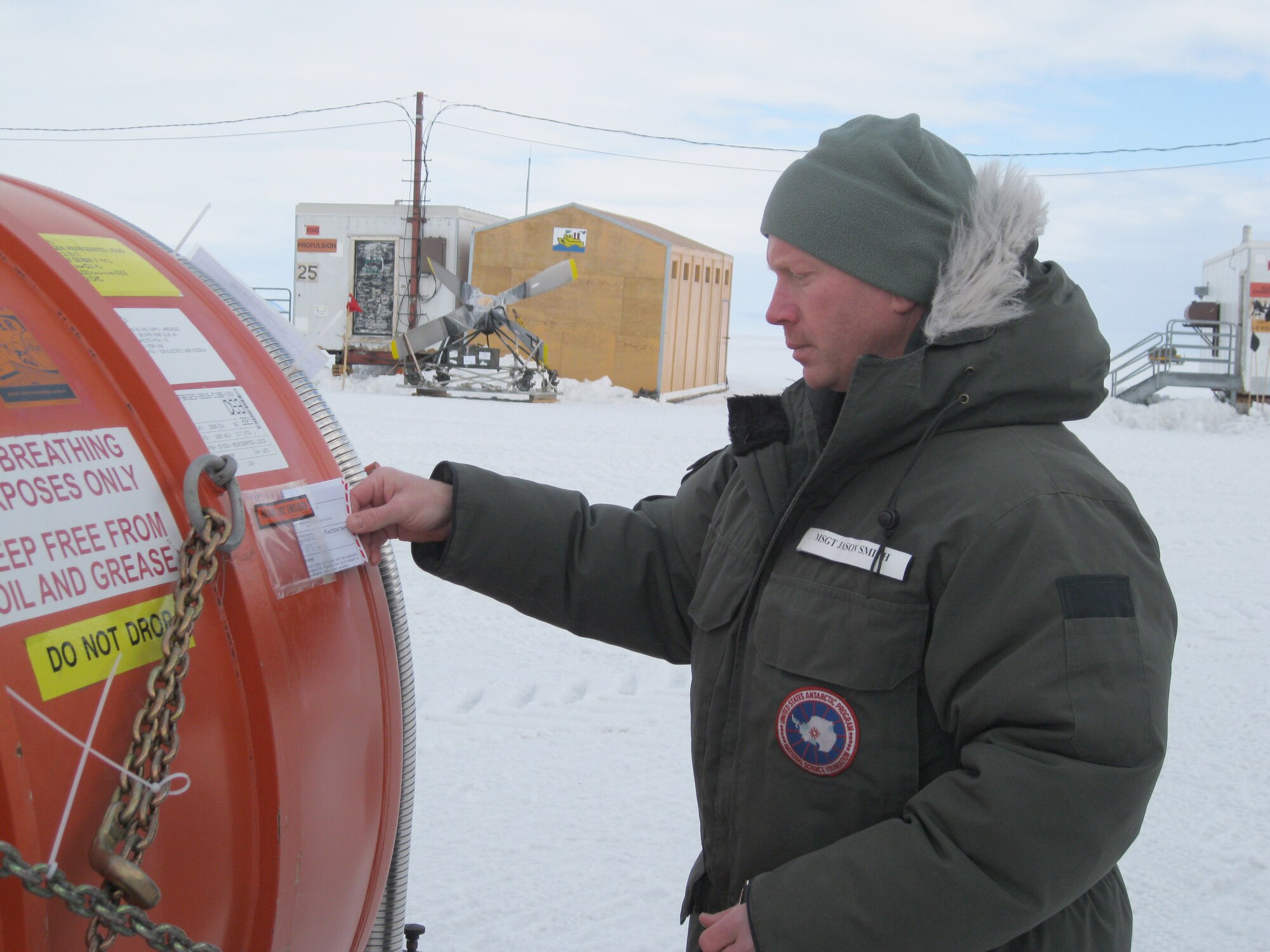 The Kentucky Air National Guard's Master Sgt. Jason Smith reads a Shippers' Declaration for Dangerous Goods to ensure that a 400-gallon liquid oxygen tank is properly prepared for flight Jan. 18, 2012, while deployed to McMurdo Station, Antarctica. Smith is supporting Operation Deep Freeze as NCOIC of joint inspection and rigging for the fourth rotation of the 2011-12 Deep Freeze season. (U.S. Air Force photo by Tech. Sgt. Raymond Graves)