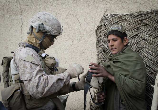 Corporal Adam McKinley, squad leader with 2nd Platoon, Weapons Co., 3rd Battalion, 7th Marine Regiment, takes a thumbprint of an Afghan boy during a two-day operation here, recently. McKinley, a 24-year-old native of Sacramento, Calif., took photographs and fingerprints of locals. Afghan National Army soldiers from 4th Tolai, 2nd Kandak, 2nd Brigade, 215th Corps, and Marines from 3rd Bn., 7th Mar., searched the area for insurgent activity.