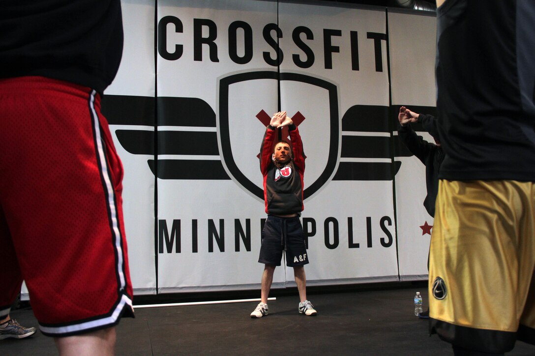 Sioux Falls, S.D., recruiter Sgt. David E. Packer leads Marines with Recruiting Station Twin Cities in a stretching exercise at CrossFit Minneapolis Feb. 5. More than a dozen recruiters attended the three-day CrossFit training seminar to enhance fitness levels within the Delayed Entry Program. For additional imagery from the event, visit www.facebook.com/rstwincities.