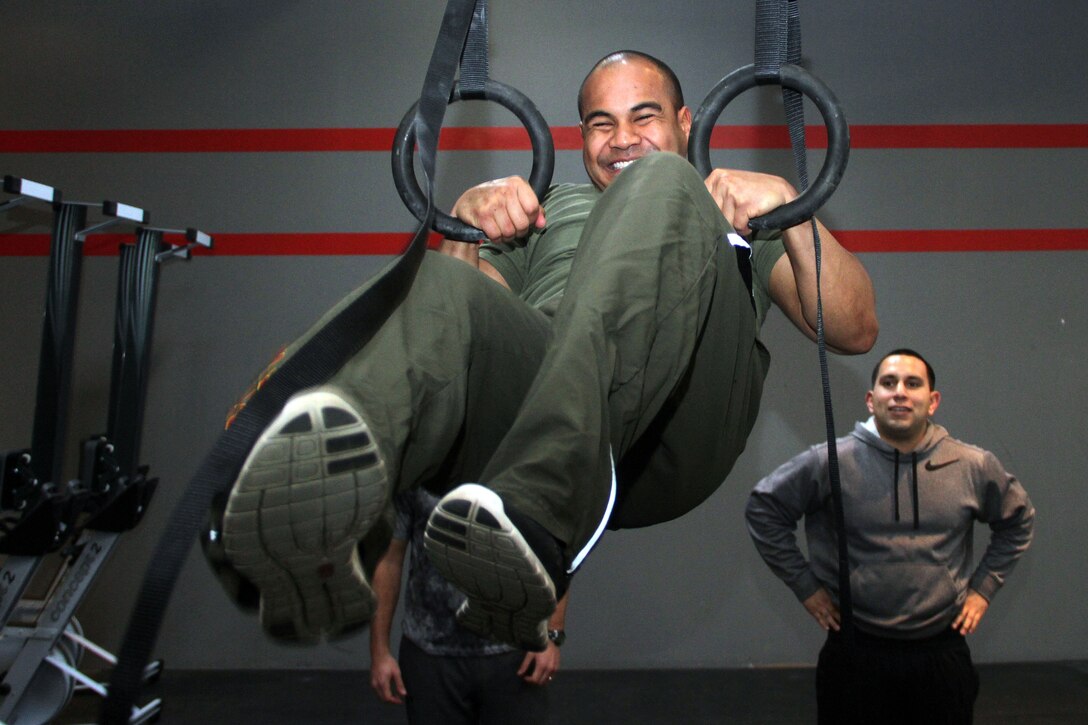 Recruiting Station Twin Cities logistics clerk Sgt. Sergio Lopez watches Roseville, Minn., recruiter Sgt. Van Tulmau attempt a muscle-up at CrossFit Minneapolis Feb. 5. More than 20 Marines attended the three-day CrossFit training seminar to enhance fitness levels within the command. For additional imagery from the event, visit www.facebook.com/rstwincities.