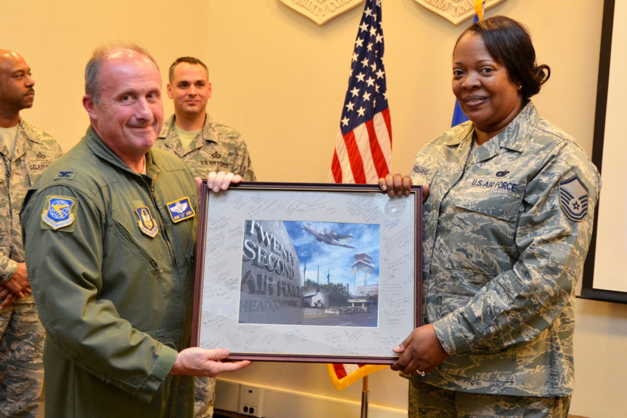 Col. John A. Jones, chief of operations training, Headquarters 22nd Air Force, presents Master Sgt. Rosalyn l. Williams, 22nd Air Force Tasker Division superintendent, presents Master Sgt. Rosalyn L. Williams, 22nd Air Force Tasker Division superintendent, with a 22 AF memento signed by her fellow Airmen during her retirement ceremony Feb. 4. Williams retired after 30 years of service to the U.S. Air force and Air force Reserve. (U.S. Air Force photo/Master Sgt. James Branch)