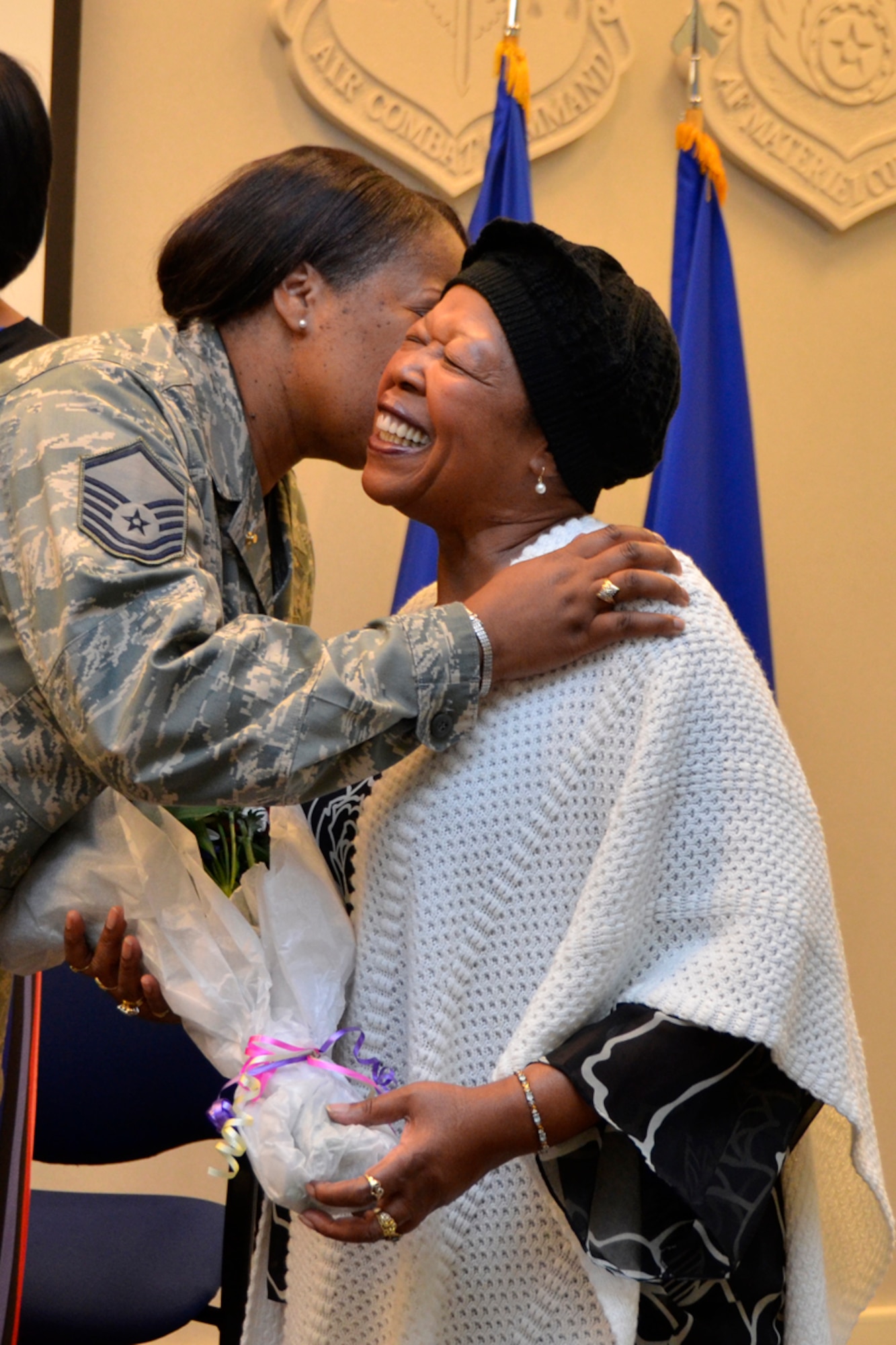 Master Sgt. Rosalyn L. Williams, 22nd Air Force Tasker Division, presents flowers to her mother during her retirement ceremony Feb. 4. Williams retired after 30 years of service to the U.S. Air force and Air force Reserve. (U.S. Air Force photo/Master Sgt. James Branch)