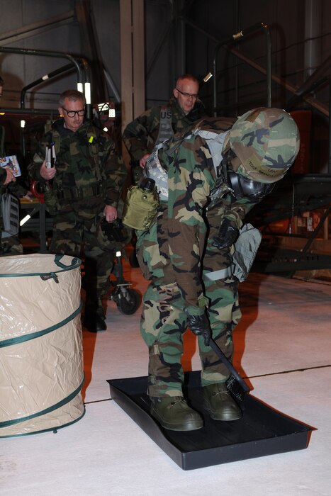 Tech. Sgt. Brenda Recksiek, 151st Logistics Readiness Squadron, demonstrates the proper way to decontaminate her overboots as part of an Ability to Survive and Operate (ATSO) exercise Feb. 4, 2012. Recksiek is wearing MOPP 4 protective gear in preparation for the 151st Air Refueling Wing's Operational Readiness Inspection in May.  (U.S. Air Force Photo by Staff Sgt. Michael Madsen/Released)