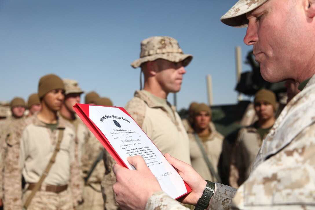 Sgt. Maj. Micheal P. Barrett, the 17th Sergeant Major of the Marine Corps, reads Master Sgt. Robert Kirby's promotion warrant in Afghanistan, Feb. 5, 2012.