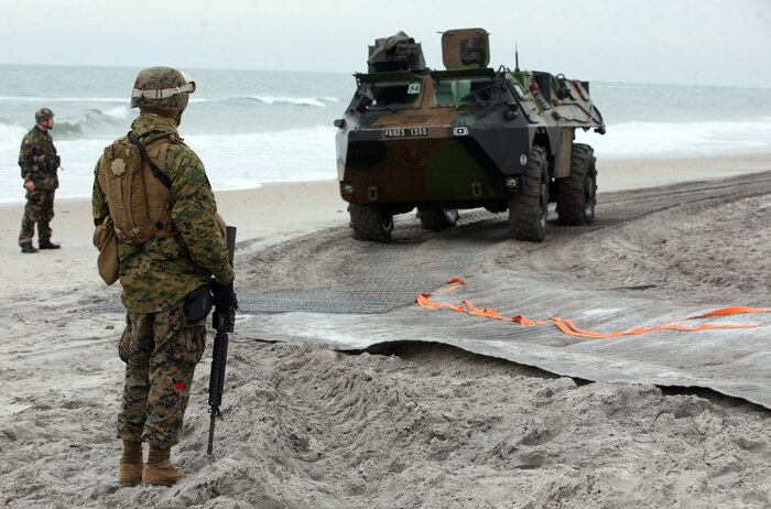 A landing support Marine with Combat Logistics Battalion 26, Combat Logistics Regiment 27, 2nd Marine Logistics Group watches as a French armored vehicle makes landfall Feb. 6, 2012, during exercise Bold Alligator 2012 aboard Camp Lejeune, N.C.  Bold Alligator is a multinational amphibious exercise designed to test the Marine Corps’ readiness by executing a beach assault.  Landing support Marines are responsible for accounting for all gear and personnel on ground and orienting troops toward the fight.