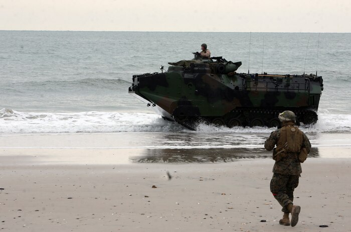 A landing support Marine with Combat Logistics Battalion 26, Combat Logistics Regiment 27, 2nd Marine Logistics Group runs to meet an armored assault vehicle after it makes landfall Feb. 6, 2012, during exercise Bold Alligator 2012 aboard Camp Lejeune, N.C.  Bold Alligator is a multinational amphibious exercise designed to test the Marine Corps’ readiness by executing a beach assault.  Landing support Marines are responsible for accounting for all gear and personnel on ground and orienting troops toward the fight.