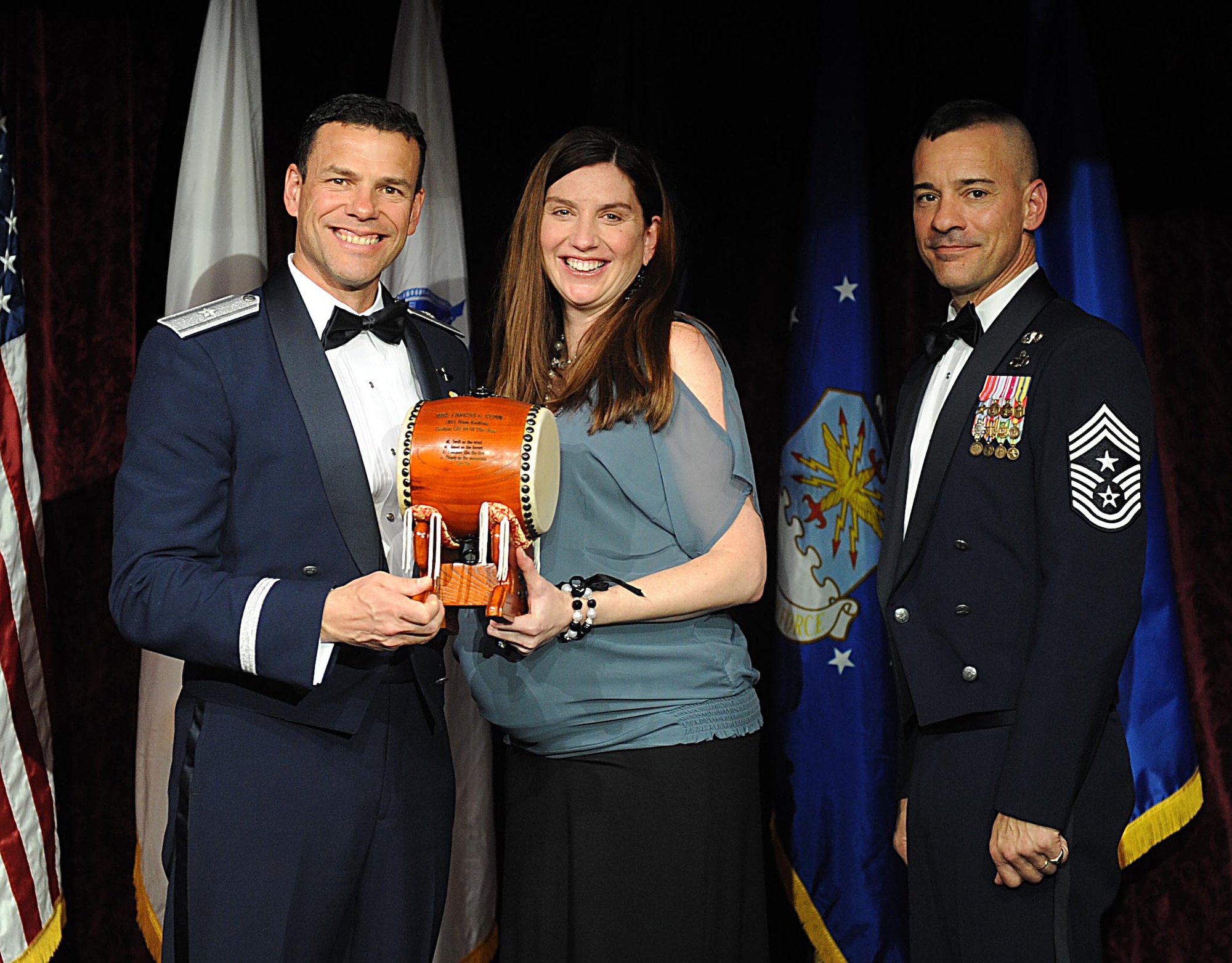 Mrs. Christina Gunn, accepts the Team Kadena Civilian of the Year, Category III Award from U.S. Air Force Brig. Gen. Matthew Molloy, 18th Wing commander, during Kadena's annual awards ceremony at the Rocker NCO Club on Kadena Air Base, Japan, Feb. 4, 2012. The awards were for Team Kadena and Wing level. (U.S Air Force photo by Airman 1st Class Brooke P. Beers/Released)
