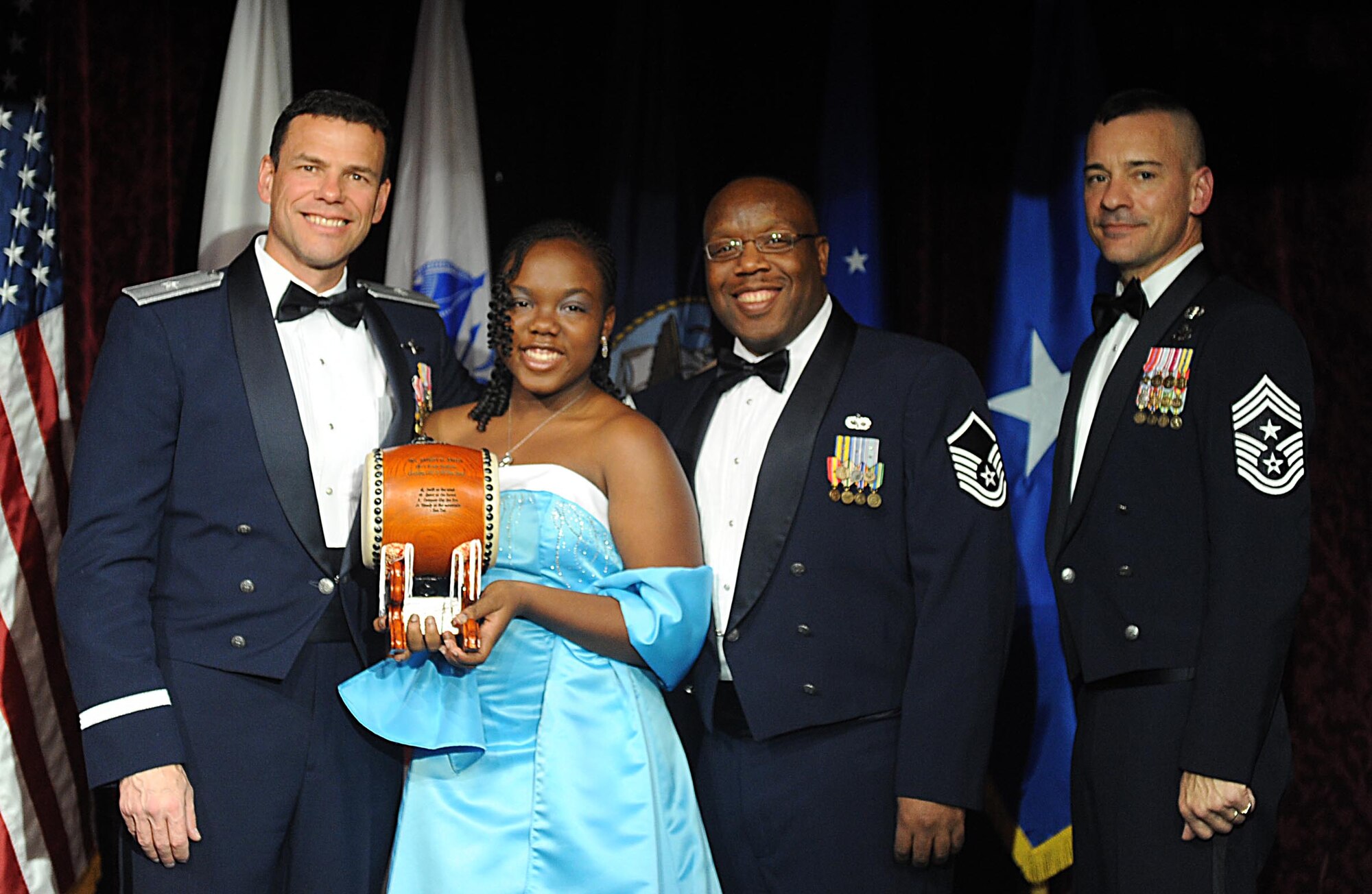 Miss. Bria Boyd,accepts the Team Kadena Civilian Catagory II award from U.S. Air Force Brig. Gen. Matthew Molloy, 18th Wing commander, on behalf of her mother Ms. Robin Boyd during Kadena's annual awards ceremony at the Rocker NCO Club on Kadena Air Base, Japan, Feb. 4, 2012. The awards were for Team Kadena and Wing level. (U.S Air Force photo by Airman 1st Class Brooke P. Beers/Released)