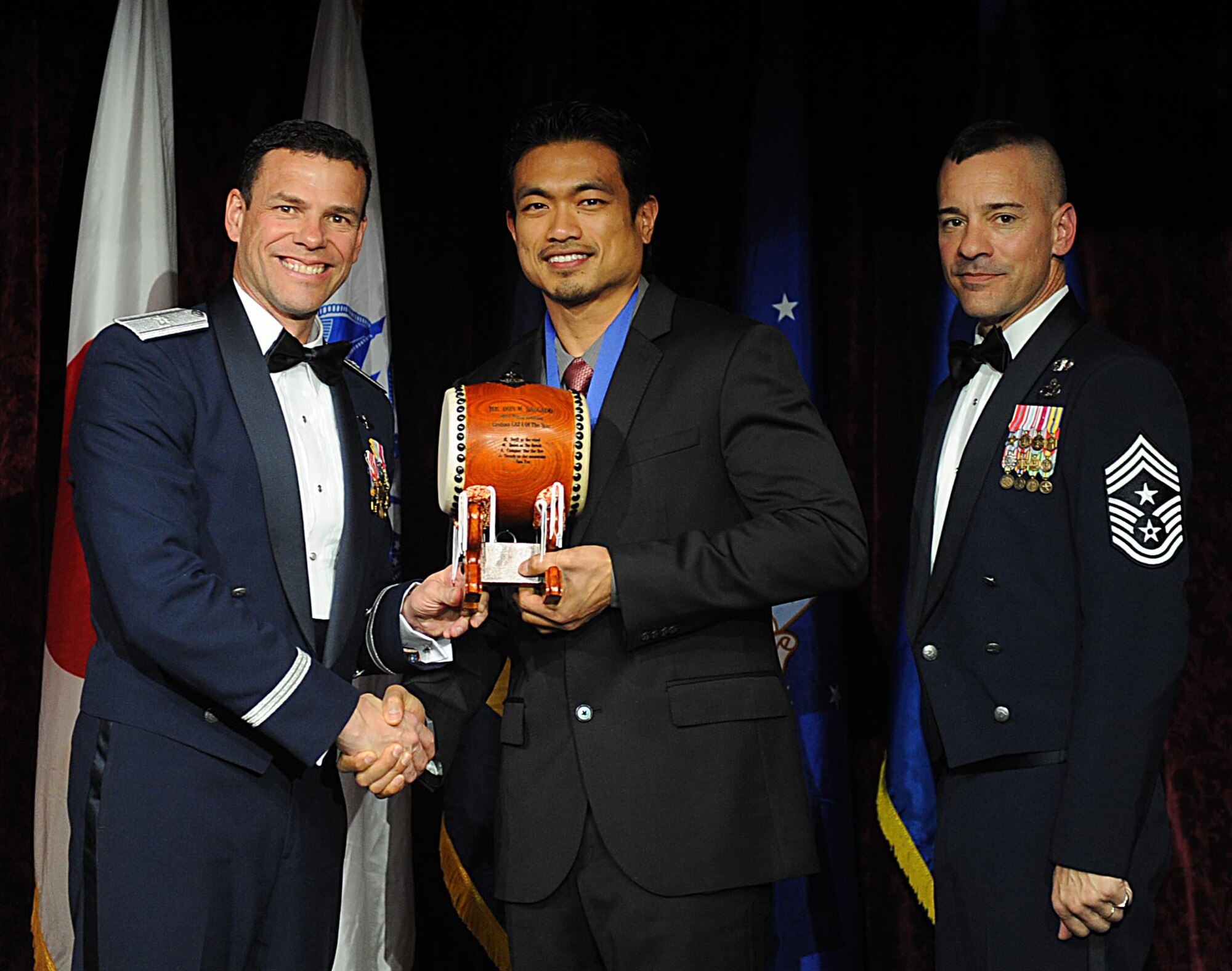 Mr. Don Salgado, accepts the Team Kadena Civilian of the Year, Category I Award from U.S. Air Force Brig. Gen. Matthew Molloy, 18th Wing commander, during Kadena's annual awards ceremony at the Rocker NCO Club on Kadena Air Base, Japan, Feb. 4, 2012. The awards were for Team Kadena and Wing level. (U.S Air Force photo by Airman 1st Class Brooke P. Beers/Released)