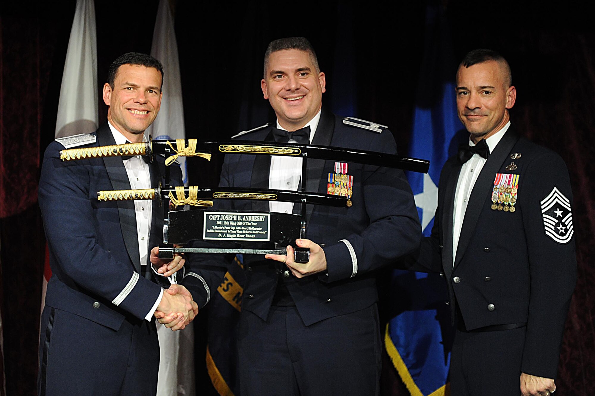 U.S. Air Force Lt. Col.Dave St Onge, on behalf of Capt. Joseph Andresky, accepts the 18th Wing Company Grade Officer of the Year Award from U.S. Air Force Brig. Gen. Matthew Molloy, 18th Wing commander, during Kadena's annual awards ceremony at the Rocker NCO Club on Kadena Air Base, Japan, Feb. 4, 2012. The awards were for Team Kadena and Wing level. (U.S Air Force photo by Airman 1st Class Brooke P. Beers/Released)