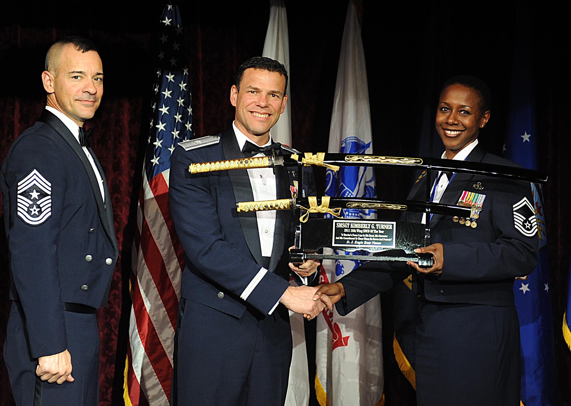 U.S. Air Force Senior Master Sgt. Kimberly Turner accepts the 18th Wing Senior Noncommisioned Officer of the Year Award from U.S. Air Force Brig. Gen. Matthew Molloy, 18th Wing commander, during Kadena's annual awards ceremony at the Rocker NCO Club on Kadena Air Base, Japan, Feb.4, 2012. The awards were for Team Kadena and Wing level. (U.S Air Force photo by Airman 1st Class Brooke P. Beers/Released)