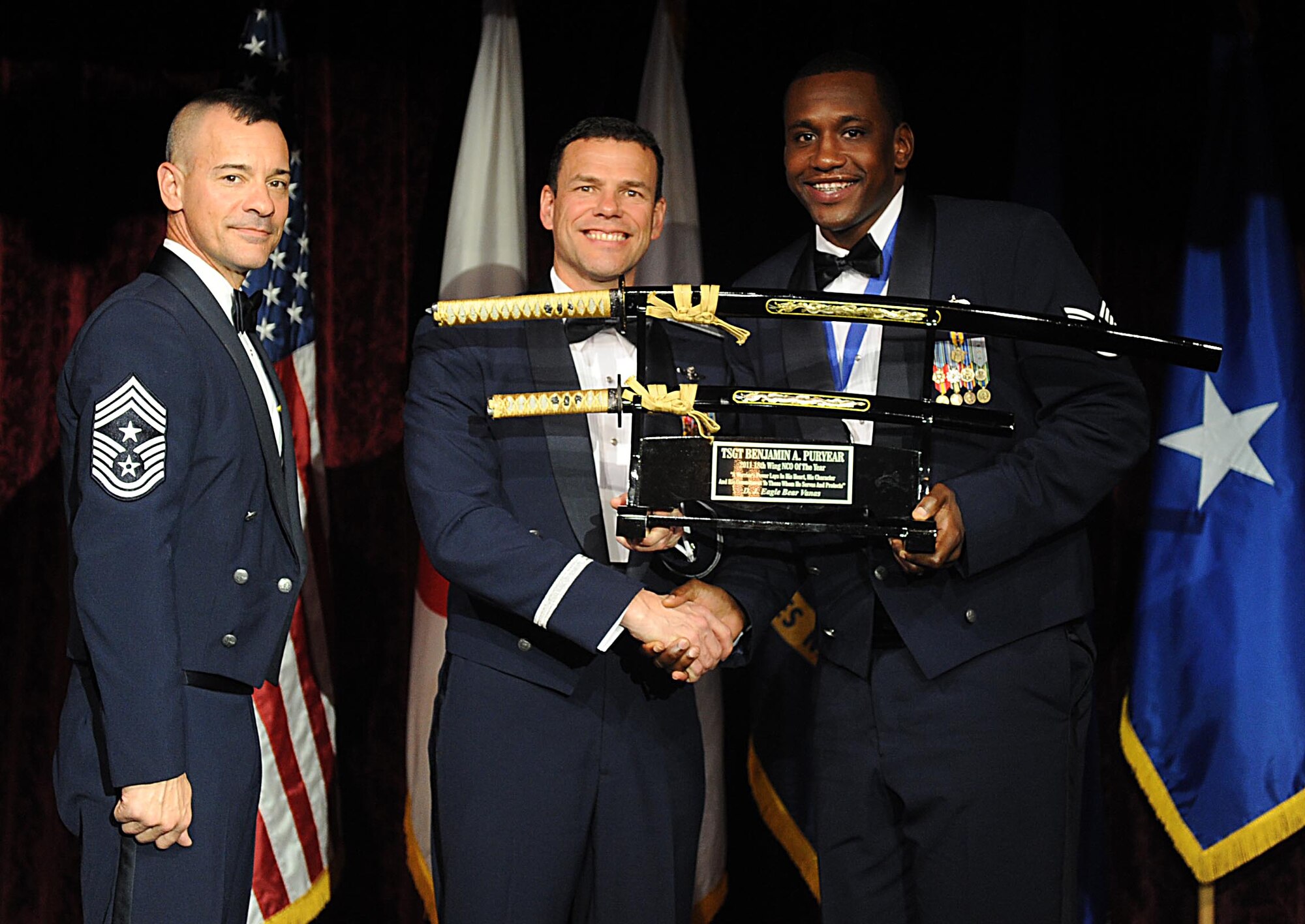 U.S. Air Force Tech Sgt. Benjamin Puryear accepts the Wing Noncommisioned Officer of the Year award from U.S. Air Force Brig. Gen. Matthew Molloy, 18th Wing commander, during Kadena's annual awards ceremony at the Rocker NCO Club on Kadena Air Base, Japan, Feb. 3, 2012. The awards were for Team Kadena and Wing level. (U.S Air Force photo by Airman 1st Class Brooke P. Beers/Released)