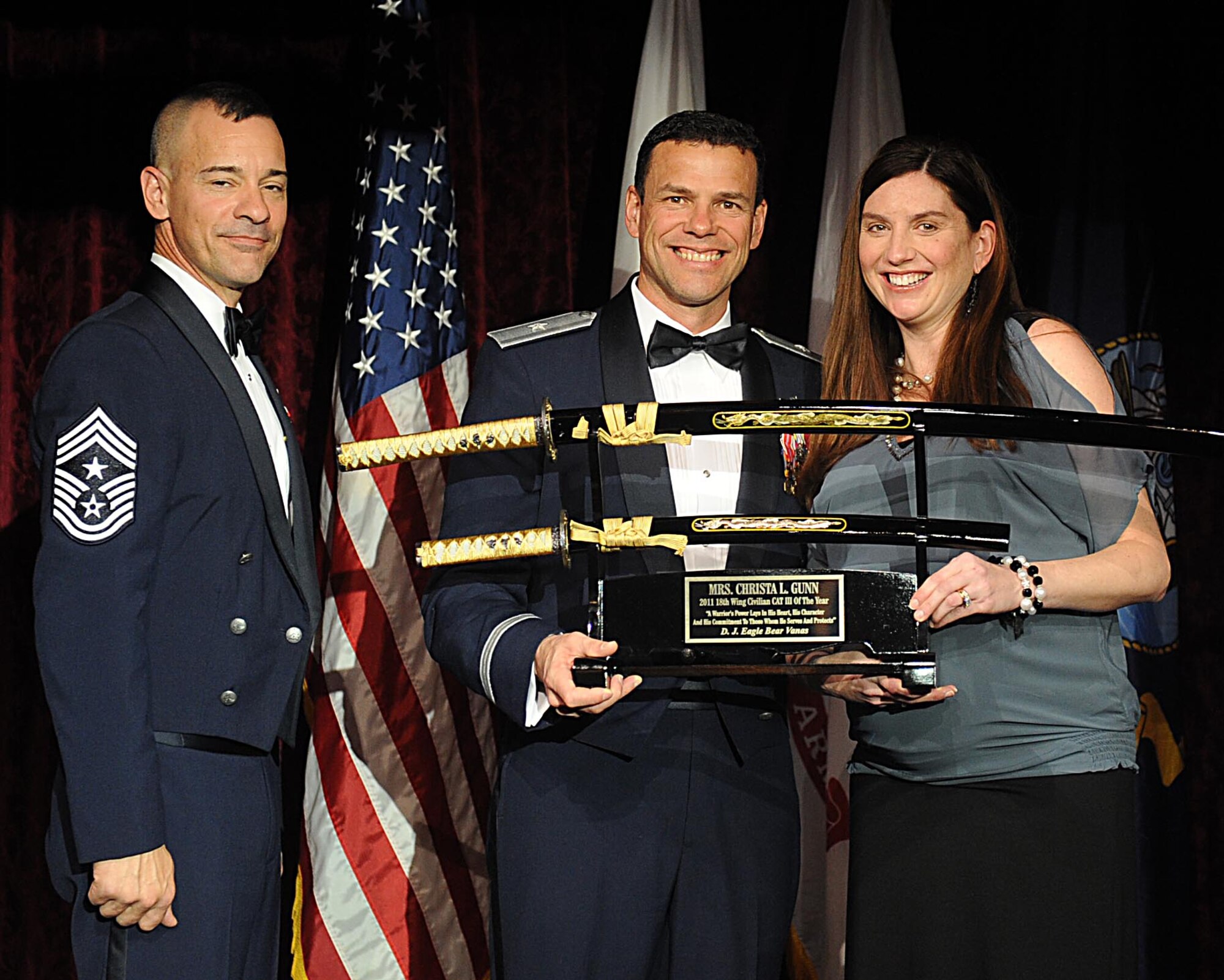 Mrs. Christa Gunn accepts the 18th Wing Civilian Catagorie III of the Year Award from U.S. Air Force Brig. Gen. Matthew Molloy, 18th Wing commander, during Kadena's annual awards ceremony at the Rocker NCO Club on Kadena Air Base, Japan, Feb. 4, 2012. The awards were for Team Kadena and Wing level. (U.S Air Force photo by Airman 1st Class Brooke P. Beers/Released)