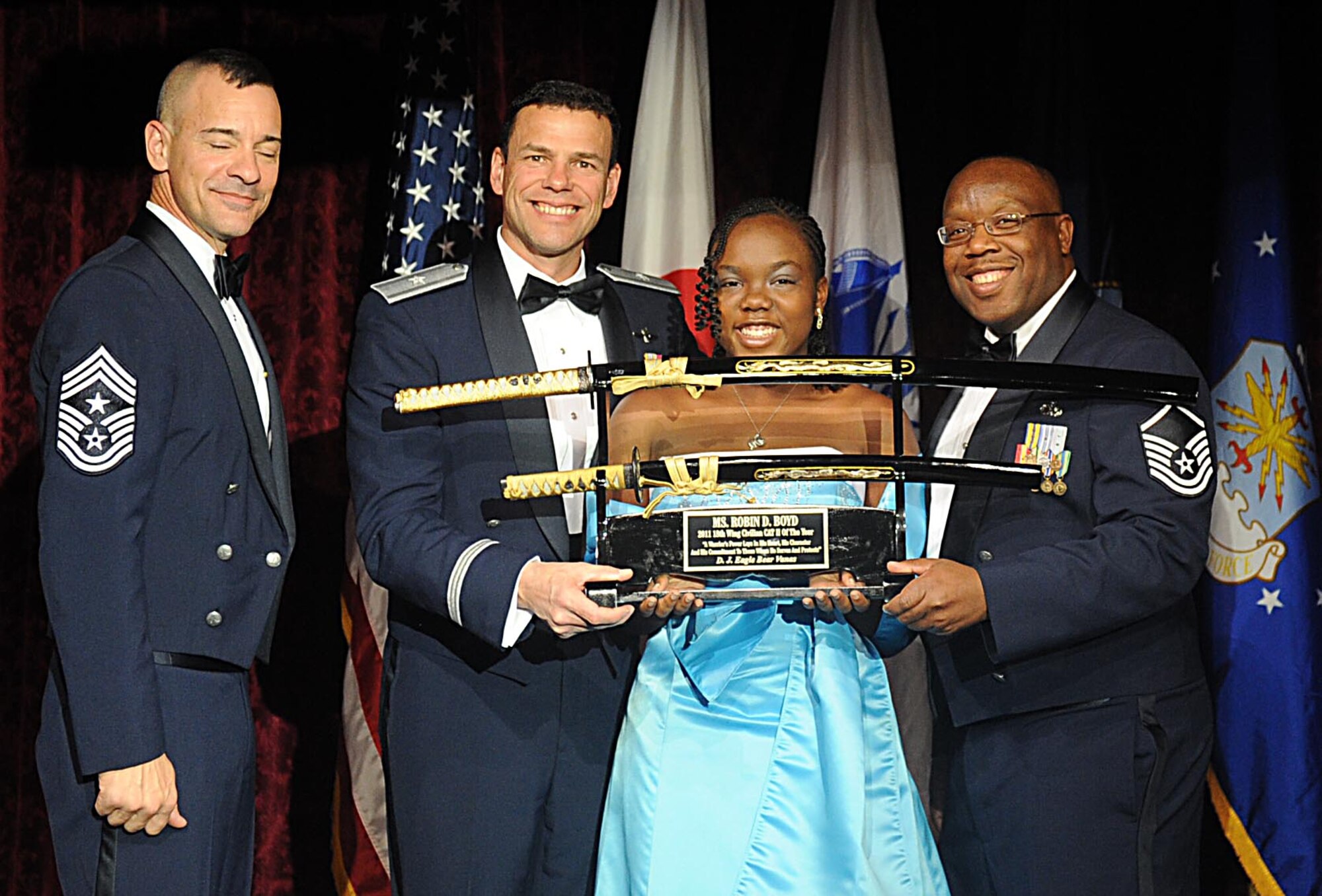 Miss. Bria Boyd,accepts the 18th Wing Civilian Catagory II award from U.S. Air Force Brig. Gen. Matthew Molloy, 18th Wing commander,on behalf of her mother Ms. Robin Boyd during Kadena's annual awards ceremony at the Rocker NCO Club on Kadena Air Base, Japan, Feb. 4, 2012. The awards were for Team Kadena and Wing level. (U.S Air Force photo by Airman 1st Class Brooke P. Beers/Released)