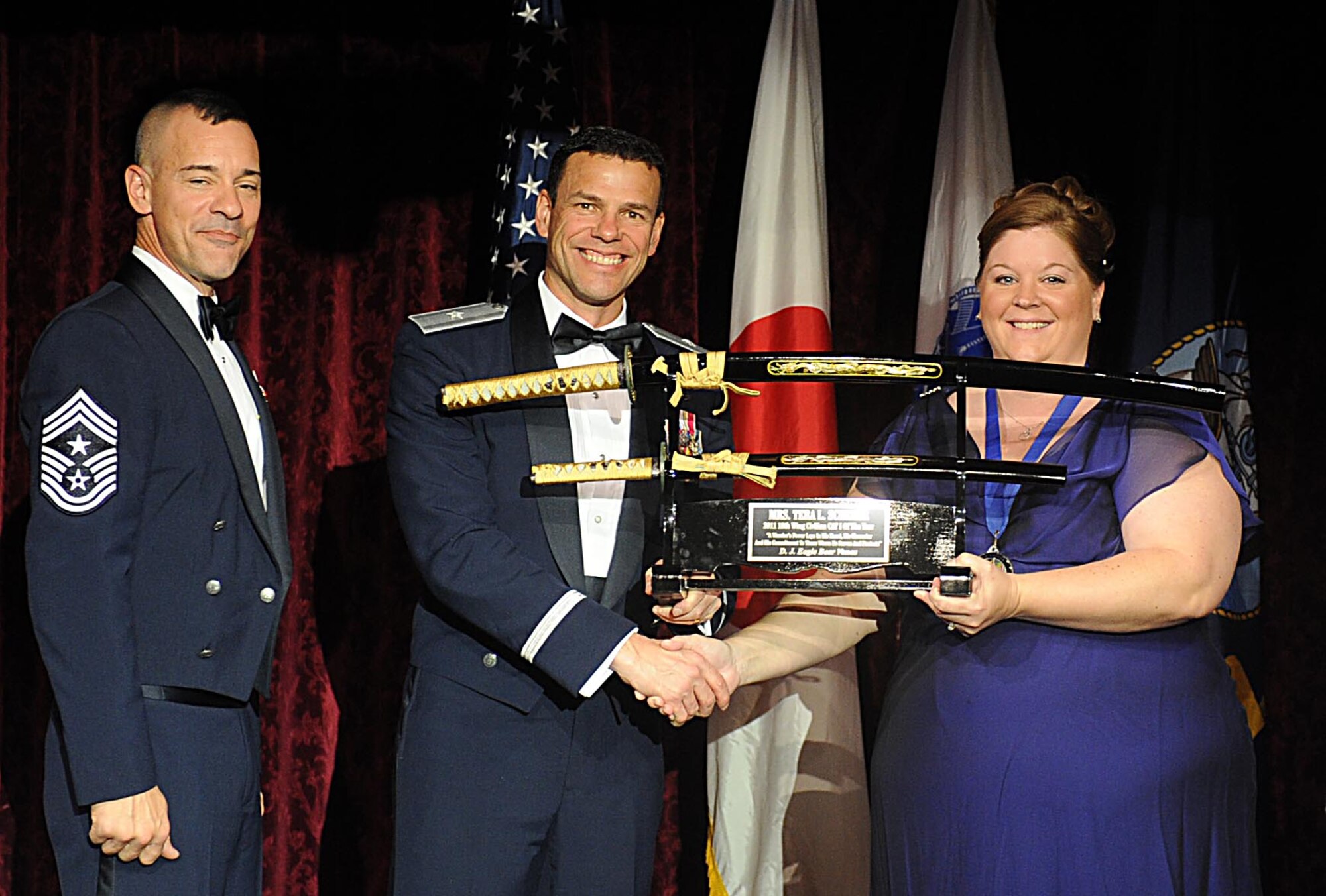Mrs. Tera Scherer accepts the 18th Wing Category I Civilian of the Year Award from U.S. Air Force Brig. Gen. Matthew Molloy, 18th Wing commander, during Kadena's annual awards ceremony at the Rocker NCO Club on Kadena Air Base, Japan, Feb.4, 2012. The awards were for Team Kadena and Wing level. (U.S Air Force photo by Airman 1st Class Brooke P. Beers/Released)