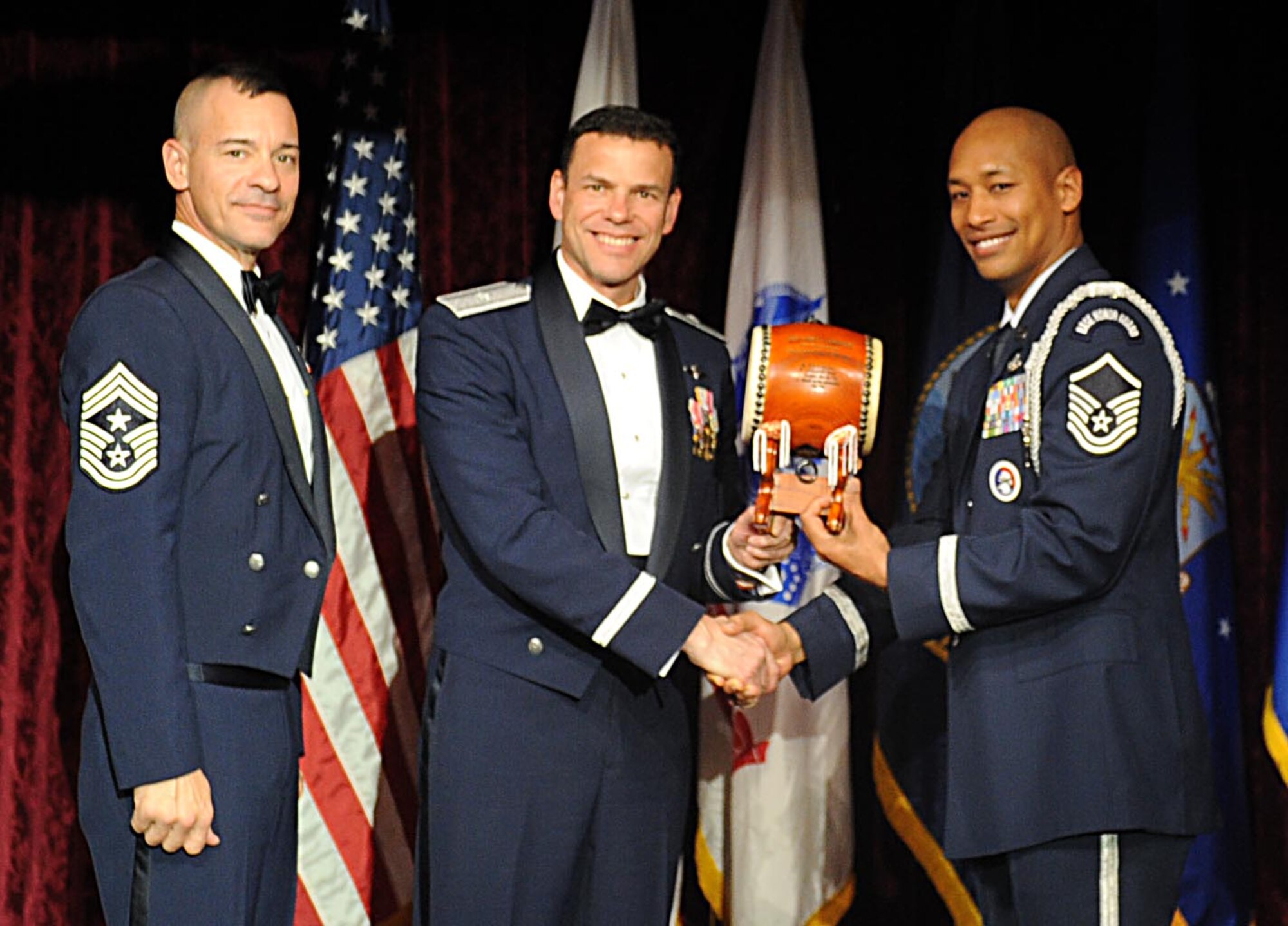U.S. Air Force Master Sgt. Jerome Bridges, on behalf of Staff Sgt. James Springer, accepts the Kadena Noncommisioned Officer of the year award from U.S. Air Force Brig. Gen. Matthew Molloy, 18th Wing commander, during Kadena's annual awards ceremony at the Rocker NCO Club on Kadena Air Base, Japan, Feb. 4, 2012. The awards were for Team Kadena and Wing level. (U.S Air Force photo by Airman 1st Class Brooke P. Beers/Released)