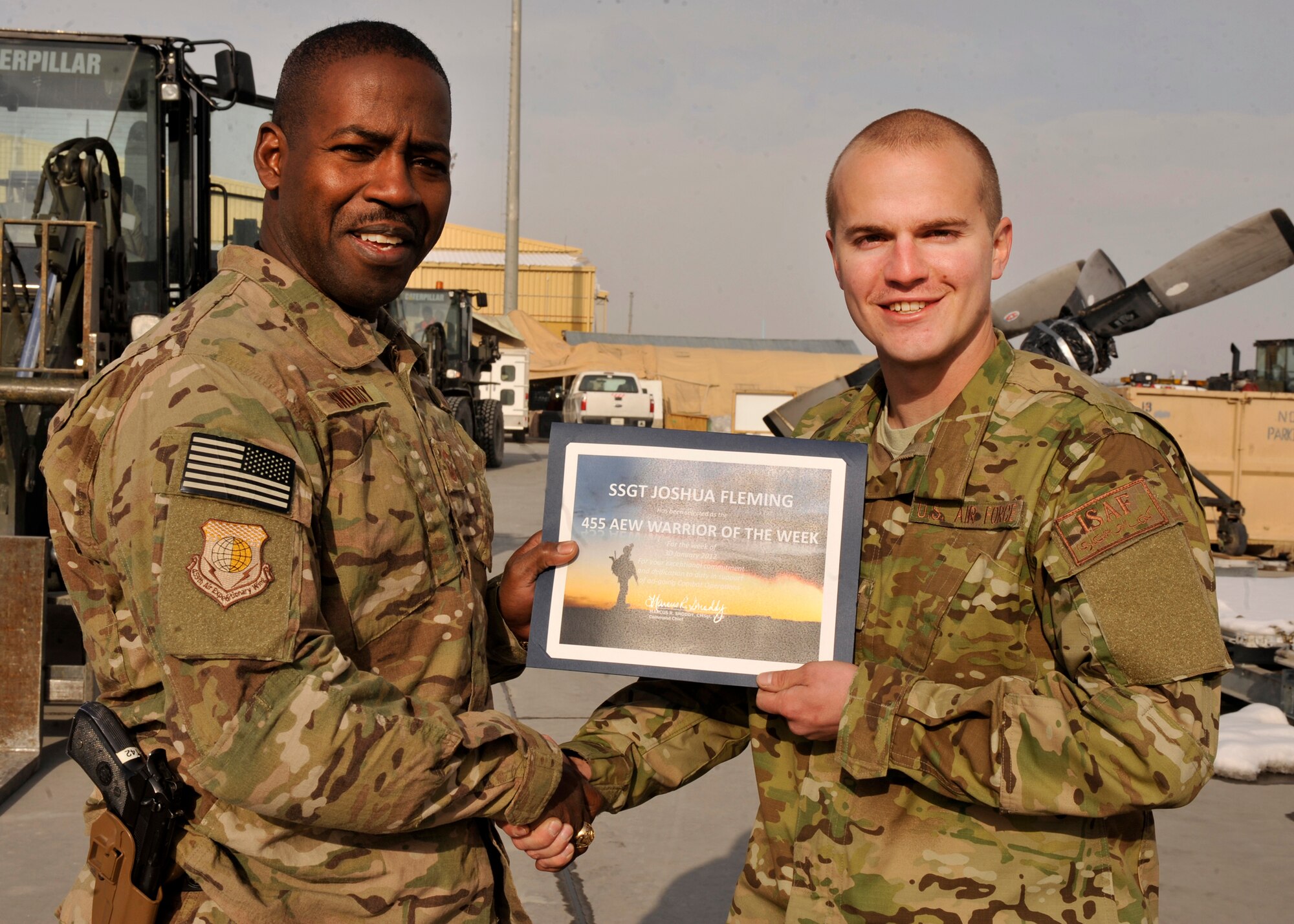 BAGRAM AIRFIELD, Afghanistan-- Staff Sgt. Joshua Fleming receives the Warrior of the Week award from Command Chief Master Sgt. Marcus Snoddy at Bagram Airfield, Afghanistan, Feb. 6, 2012. Fleming is a ramp service load team chief with the 455 Expeditionary Aerial Port Squadron and earned the Warrior of the Week award for his hard work and dedication to excellence. (U.S. Air Force photo/ Airman 1st Class Ericka Engblom)