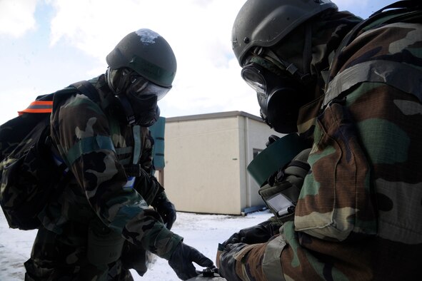 Staff Sgt. Demetrius Williams and Tech. Sgt. Steven Jackson, 8th Comptroller Squadron finance members, change chemical agent detection paper (M8) at stanchions around their facility at Kunsan Air Base, Republic of Korea, during a peninsula-wide operational readiness exercise Feb. 2, 2012. Kunsan participated in a PENORE to test its ability of performing during wartime conditions no matter what the season may be. (U.S. Air Force photo by Staff Sgt. Rasheen A. Douglas/Released)