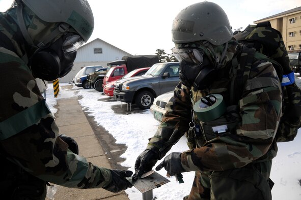 Staff Sgt. Demetrius Williams and Tech. Sgt. Steven Jackson, 8th Comptroller Squadron finance members, change chemical agent detection paper (M8) at stanchions around their facility at Kunsan Air Base, Republic of Korea, during a peninsula–wide operational readiness exercise Feb. 2, 2012. Kunsan participated in a PENORE to test its ability of performing during wartime conditions no matter what the season may be. (U.S. Air Force photo by Staff Sgt. Rasheen A. Douglas/Released)