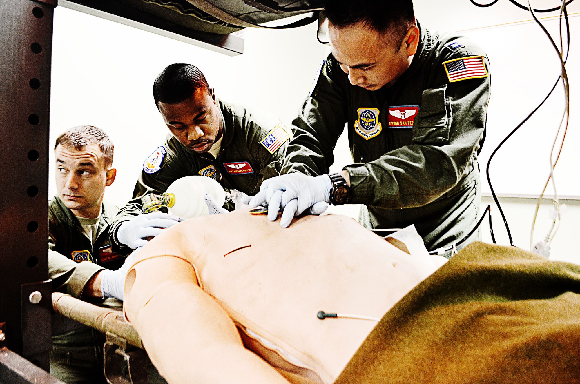 Staff Sgts. Anson Norton and Michael Fulton, and Capt. Erwin San Pedro, 375th Aeromedical Evacuation Squadron, demonstrate lifesaving responses on a Mediman simulated patient during the grand opening tour of their new building at Scott Air Force Base, Ill., Feb. 6, 2012.  The building will house 163 active-duty, Guard and Reserve personnel whose mission is to bring home the wounded from battlefield.  The $7.4 million, 21,500 sq. ft. structure replaces Bldg. 505, which will be demolished by the end of March 2012.  (U.S. Air Force photo/Karen Petitt)