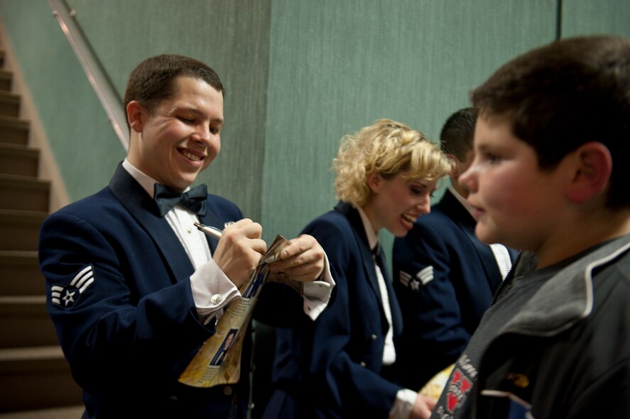 U.S. Air Force Zachery Rayburn, Tops in Blue vocalist, signs his autograph at the Mathis Auditorium, Valdosta, Ga., Feb. 2, 2012. The Tops in Blue crew spent about 30 minutes signing autographs after the show and expressed their appreciation for the support they had been given. (U.S. Air Force photo by Staff Sgt. Jamal D. Sutter/Released) 