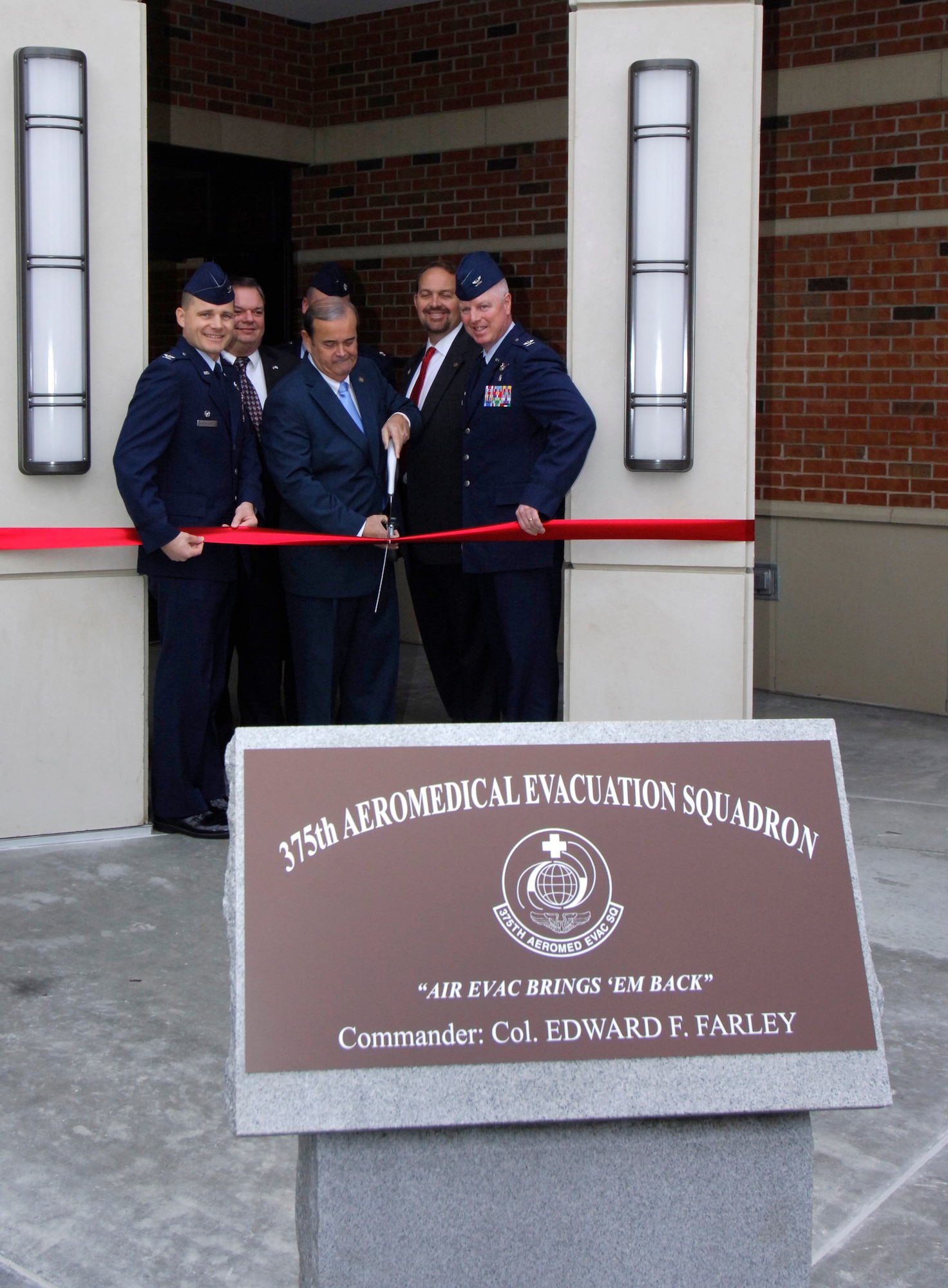 Congressman Jerry Costello, flanked by Col. Michael Hornitschek, 375th Air Mobility Wing Commander, and Col. Edward Farley, 375th Aeromedical Evacuation Squadron commander cut the ribbon for the new 375th AES facility at Scott Air Force Base, Ill., Feb. 6, 2012. The new AES facility had been under construction since March 20, 2011, and replaces an older structure--Bldg. 505--that flooded frequently and could not be salvaged with renovations.  It is scheduled to be demolished by the end of March 2012.  The new facility houses 163 active-duty, Guard and Reserve personnel whose mission is to bring the wounded back from the battlefields to their home stations.  (U.S. Air Force photo/Airman 1st Class Jake Eckhardt)
