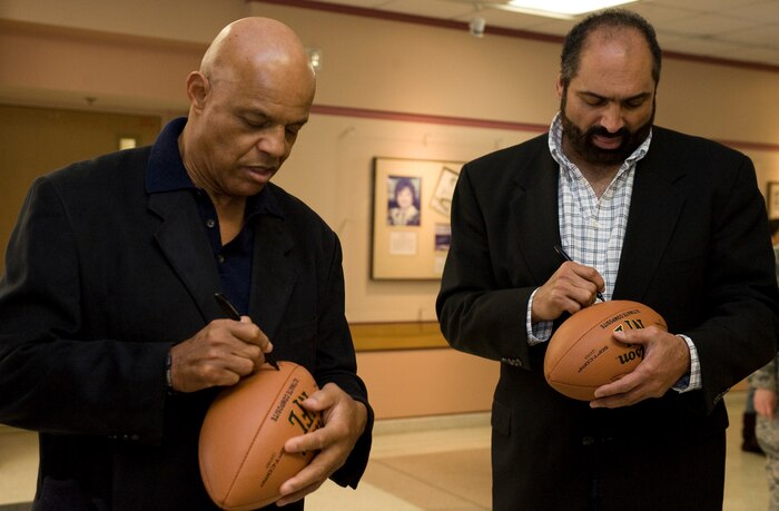 Franco Harris and Lyndell Mitchell, former National Football League players, autograph footballs Feb. 3, 2012, at Nellis Air Force Base, Nev.  Harris and Mitchell are volunteers for Soldiers' Angels, a volunteer-led, non profit organization that provides aid and comfort to the men and women of the U.S. Army, Marines, Navy, Air Force and Coast Guard, U.S. veterans and their families. (U.S. Air Force photo by Airman 1st Class Matthew Lancaster)