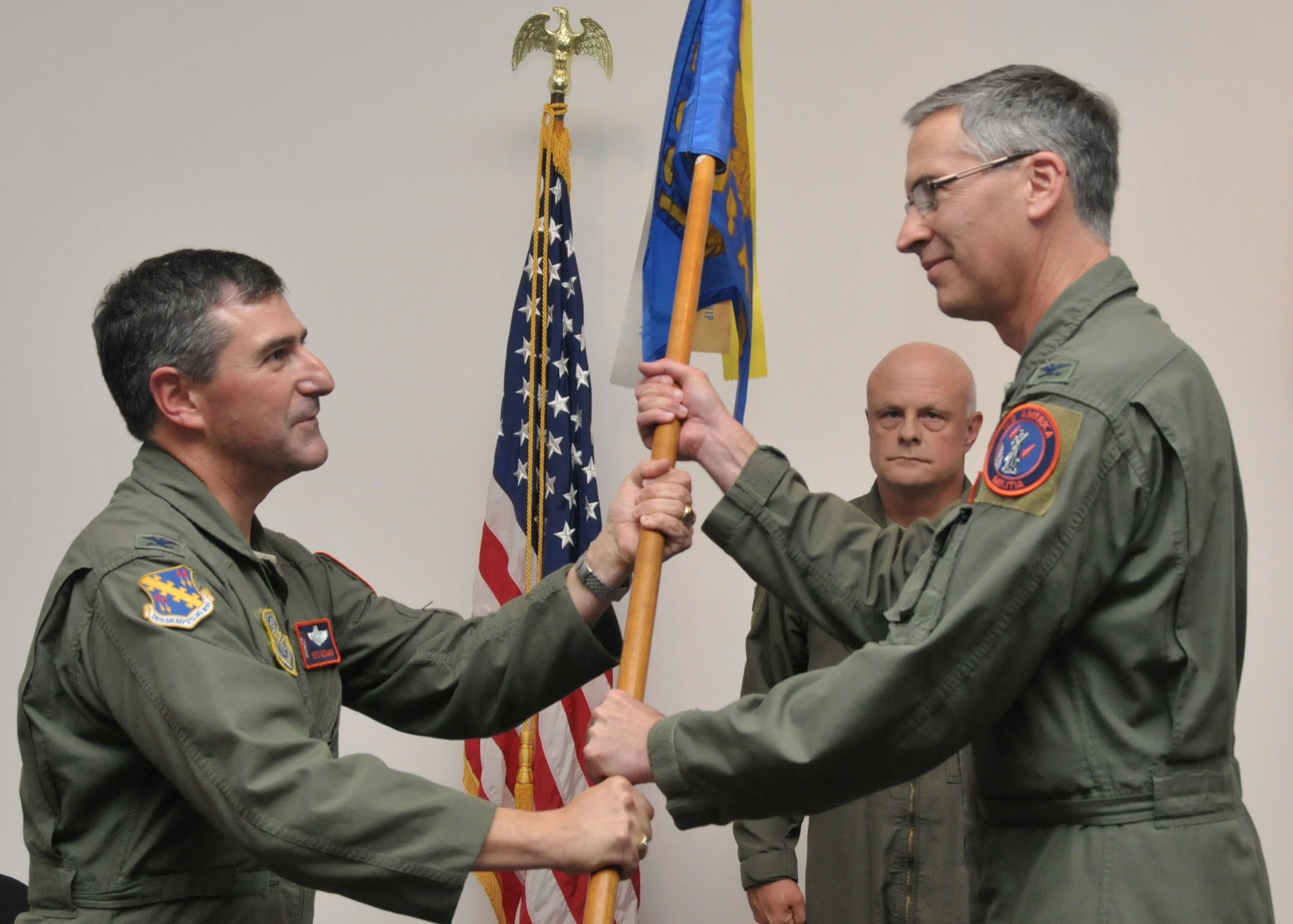 Col. Peter Nezamis (left) hands the 126th Operations Group guidon to Col. Jeffrey Jacobson in a traditional military Change of Command ceremony on Nov. 5, 2011 at Scott AFB, Ill. By accepting the guidon, Col. Jacobson symbolically accepts the responsibilities as commander over the Airmen of the group. (National Guard photo by Master Sgt. Franklin Hayes)